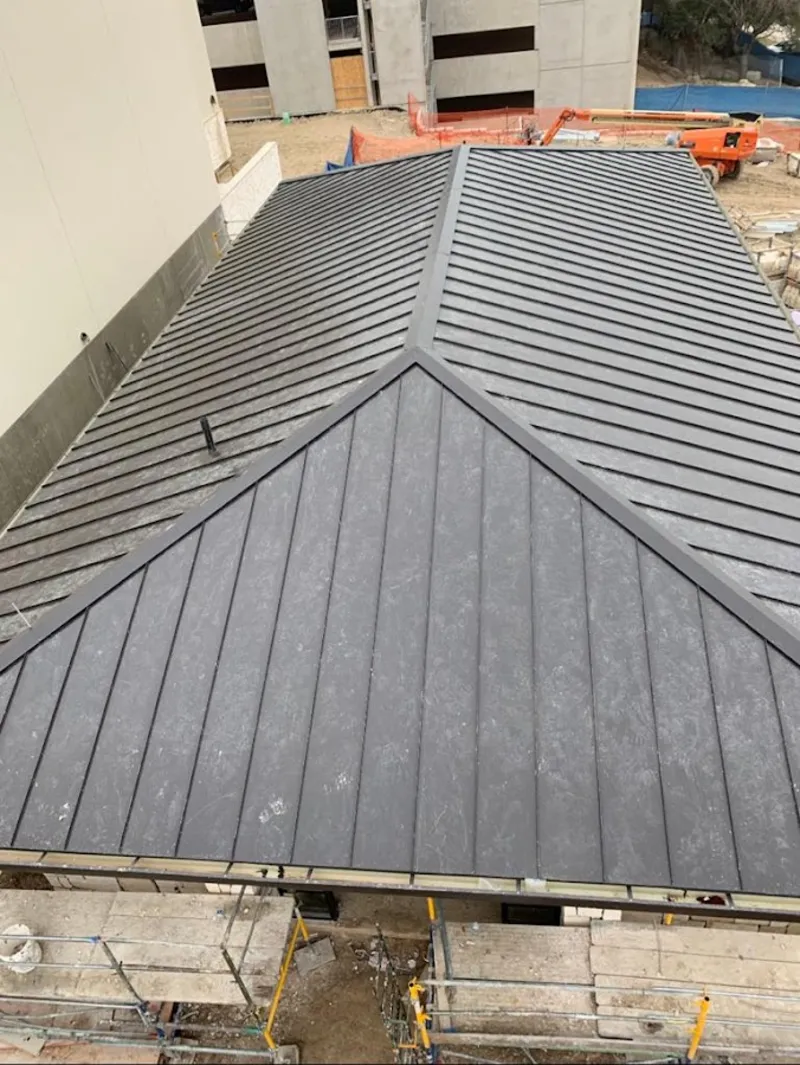 Commercial metal roof construction with crane equipment in Olyphant